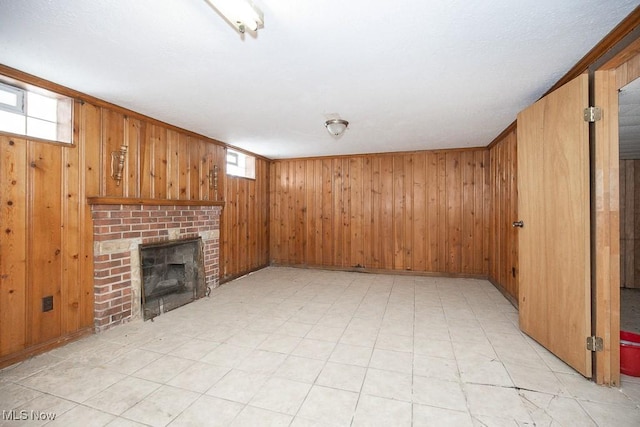 unfurnished living room with a fireplace and wooden walls