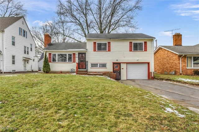 split level home with a garage, a chimney, a front lawn, and entry steps