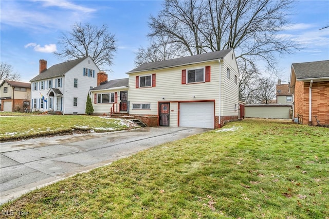 tri-level home featuring a garage, a front yard, and driveway