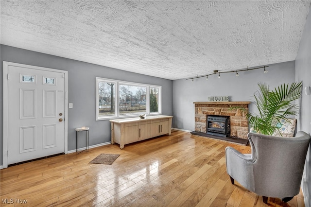 living room with light wood-style floors, a fireplace, and baseboards