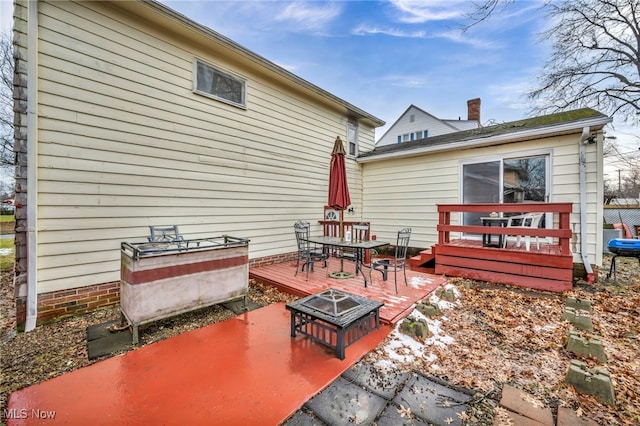 back of property with a patio, an outdoor fire pit, outdoor dining area, and a wooden deck