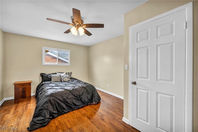 bedroom featuring ceiling fan, baseboards, and wood finished floors