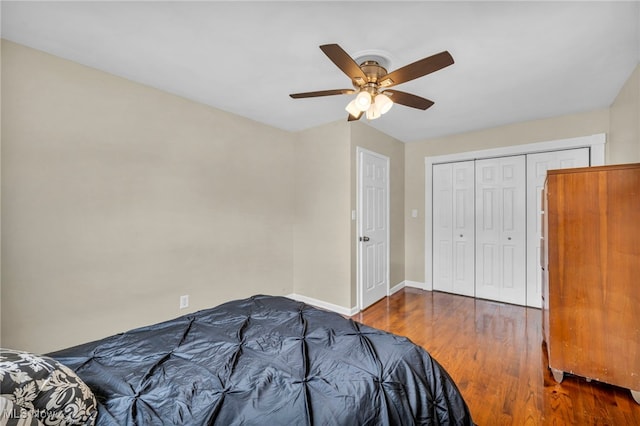 bedroom with a closet, ceiling fan, baseboards, and wood finished floors