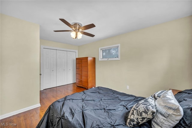 bedroom featuring a ceiling fan, a closet, dark wood finished floors, and baseboards