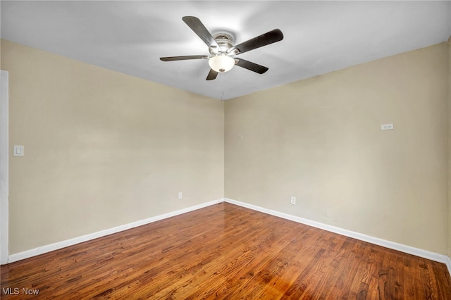 spare room featuring ceiling fan, baseboards, and wood finished floors