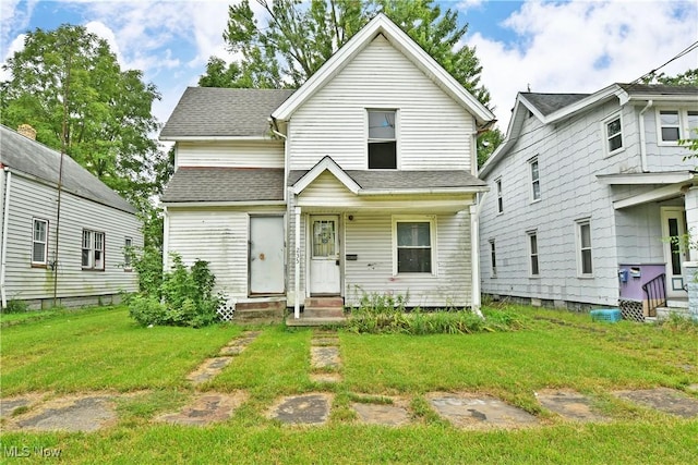 view of front of house with entry steps, roof with shingles, and a front yard