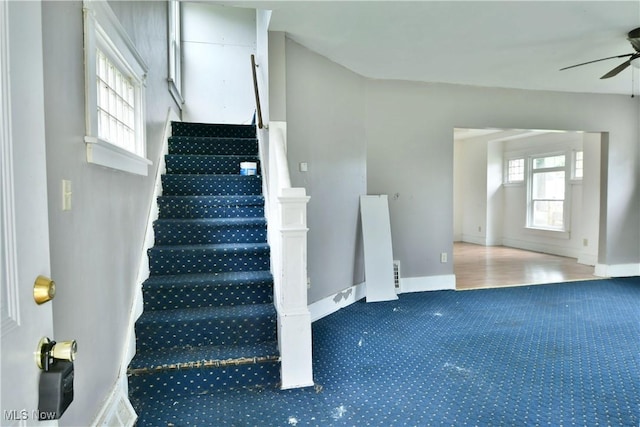 staircase featuring ceiling fan and baseboards