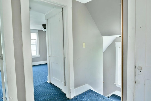 hall featuring carpet floors and lofted ceiling