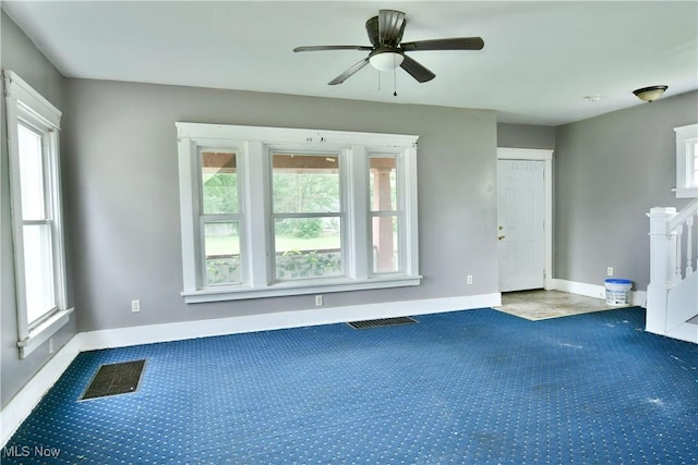 carpeted empty room featuring visible vents and plenty of natural light