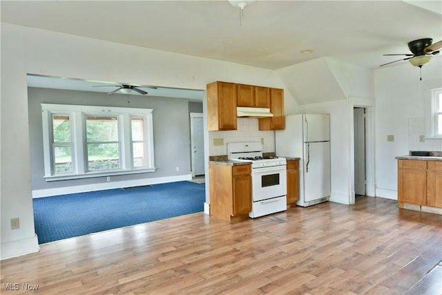 kitchen with brown cabinets, light countertops, open floor plan, white appliances, and under cabinet range hood