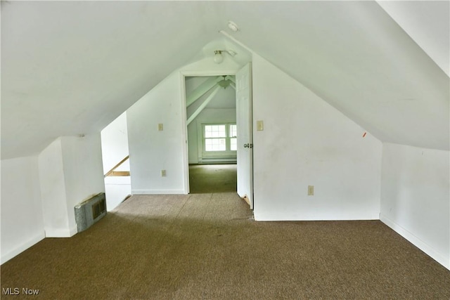 additional living space with lofted ceiling, visible vents, and dark carpet