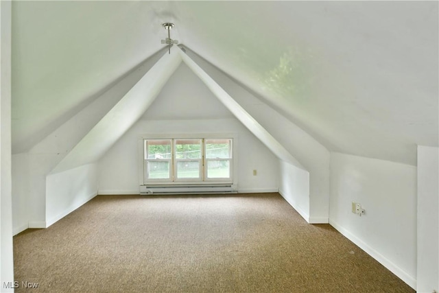 additional living space featuring a baseboard heating unit, carpet, lofted ceiling, and baseboards