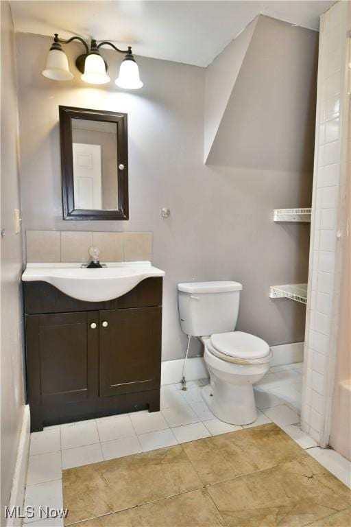 bathroom with tile patterned floors, vanity, toilet, and baseboards