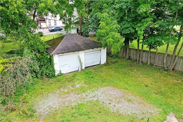 view of yard with an outbuilding, fence, and a detached garage