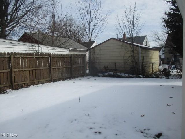 yard covered in snow with fence