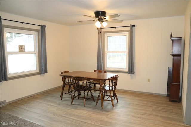 dining space with a ceiling fan, light wood-type flooring, and baseboards