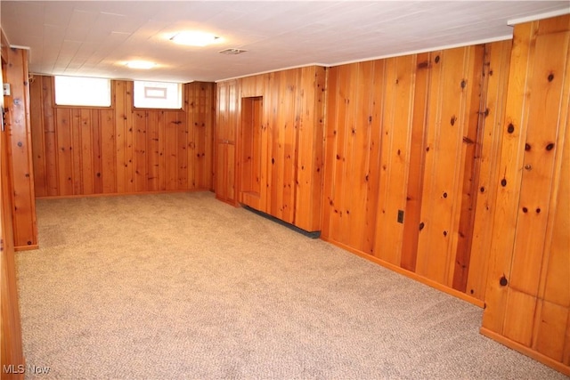 basement with light colored carpet and wood walls