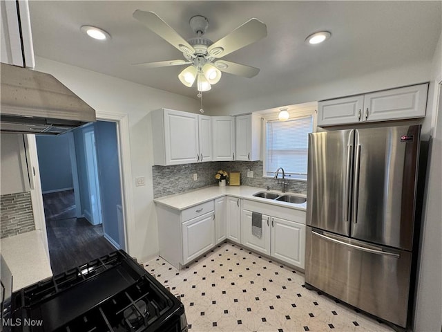 kitchen with freestanding refrigerator, black range with gas stovetop, light countertops, white cabinetry, and a sink