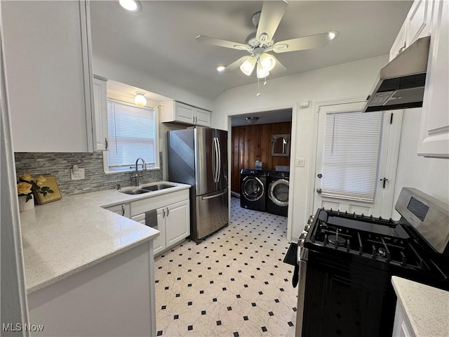 kitchen with extractor fan, a sink, white cabinetry, appliances with stainless steel finishes, and washing machine and clothes dryer