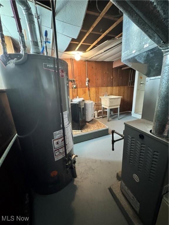 unfinished basement featuring water heater, a sink, and wooden walls