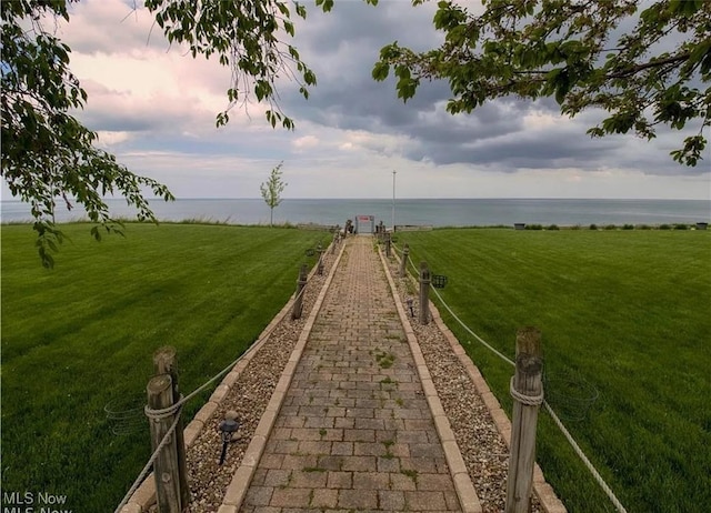 view of property's community featuring a water view and a yard