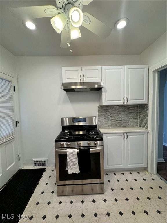 kitchen with visible vents, white cabinets, light countertops, under cabinet range hood, and stainless steel range with gas stovetop