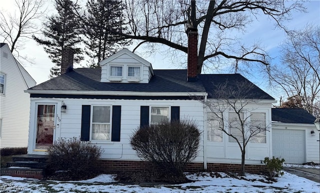 view of front of property with a garage, roof with shingles, and a chimney