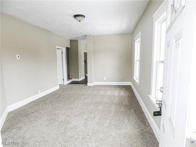 carpeted spare room with baseboards