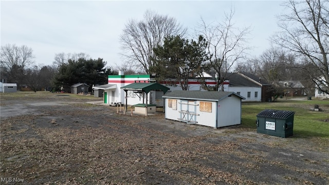 view of front facade with a residential view, an outdoor structure, and a storage unit