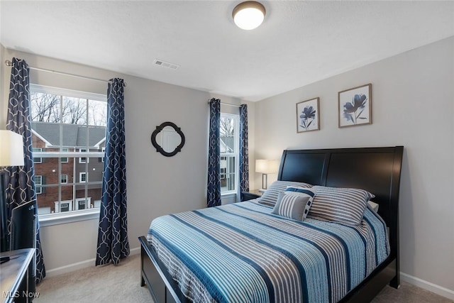 bedroom featuring baseboards, visible vents, and light colored carpet