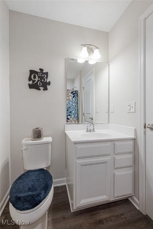 full bathroom featuring vanity, wood finished floors, toilet, and baseboards