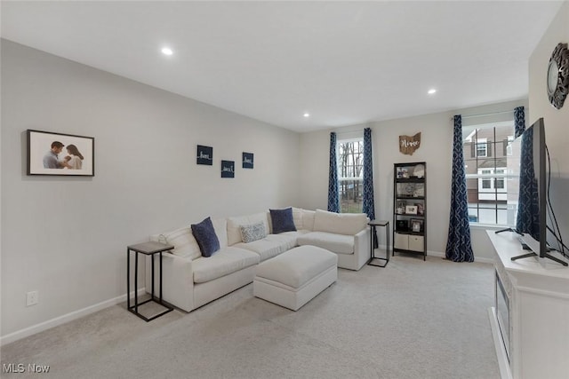 living room with recessed lighting, baseboards, and light colored carpet