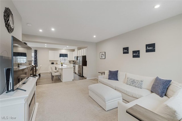 living area with baseboards and recessed lighting