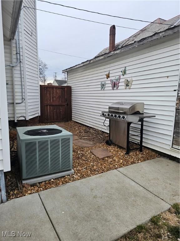 view of patio / terrace with central AC unit, a grill, and fence