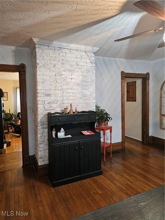 interior space featuring dark wood-type flooring, crown molding, and ceiling fan