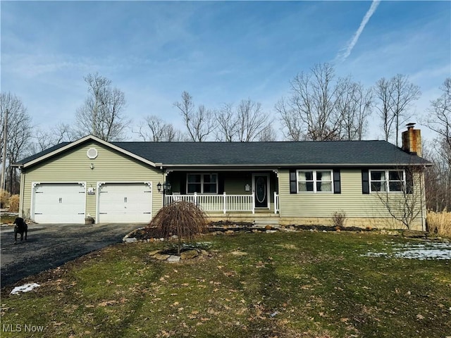 ranch-style home with driveway, a garage, a chimney, and a front lawn