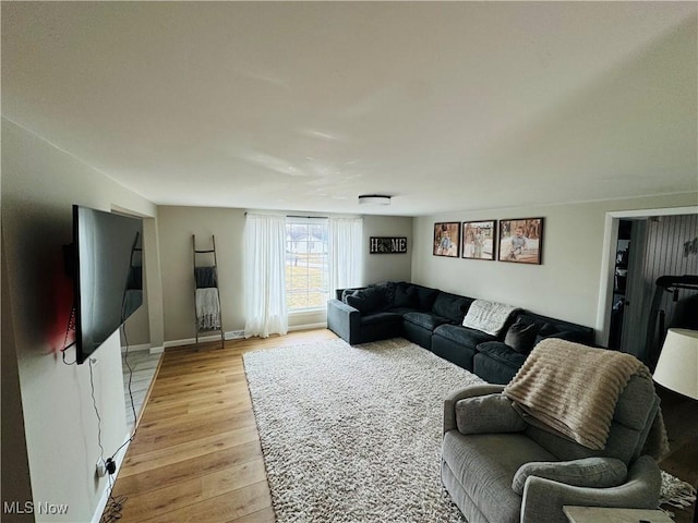 living area with light wood-type flooring and baseboards