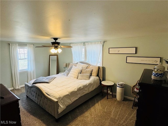 bedroom featuring dark carpet, a ceiling fan, and baseboards