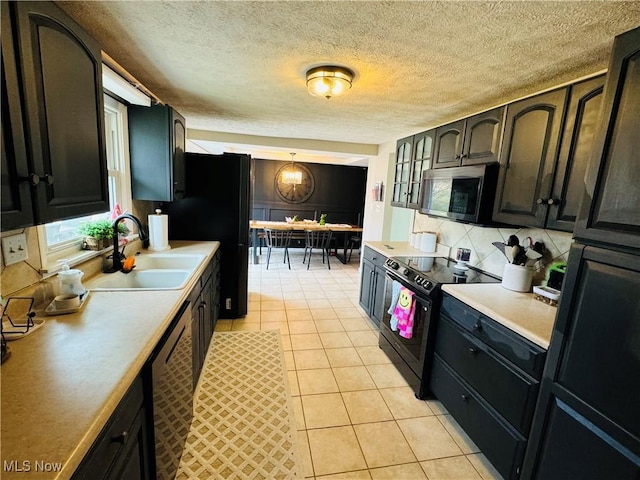 kitchen featuring a sink, black appliances, light tile patterned floors, and light countertops