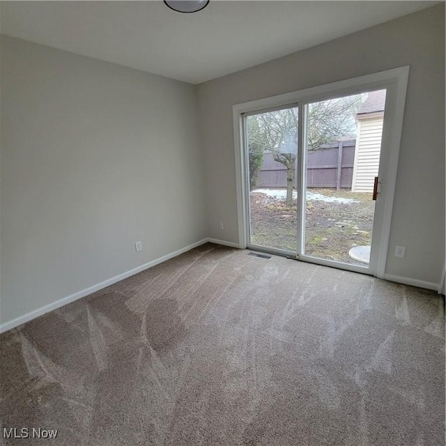 carpeted empty room with visible vents and baseboards