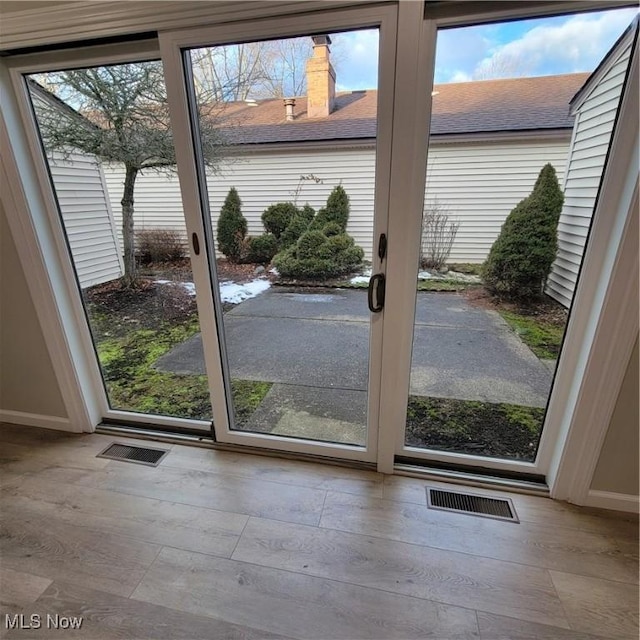 doorway with light wood-style floors, a wealth of natural light, and visible vents