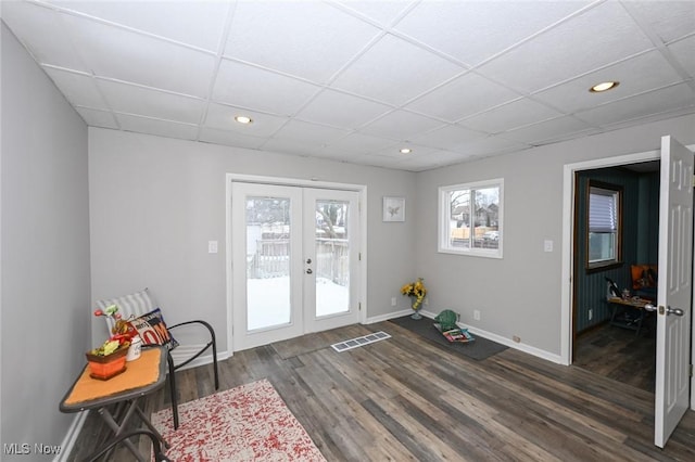 doorway featuring french doors, recessed lighting, dark wood-type flooring, a drop ceiling, and baseboards