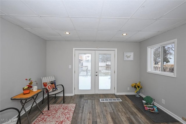 doorway to outside featuring baseboards, visible vents, dark wood-style flooring, and french doors