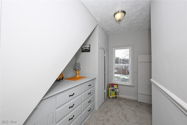 interior space featuring light carpet and a textured ceiling