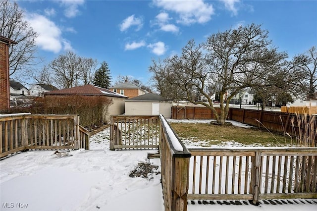 snow covered deck with a fenced backyard and a residential view