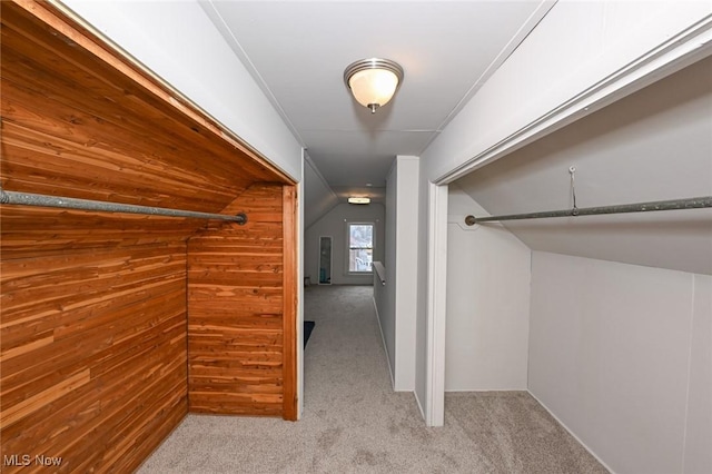 walk in closet featuring lofted ceiling and light carpet