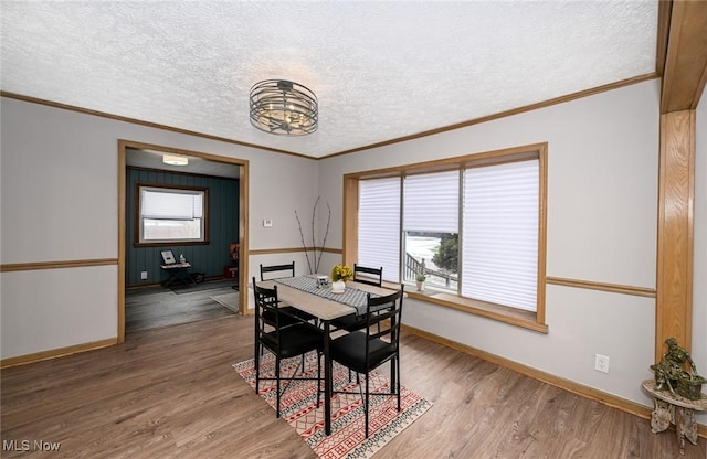 dining area featuring a textured ceiling, wood finished floors, and a healthy amount of sunlight