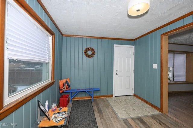 entryway featuring baseboards, wood finished floors, and crown molding