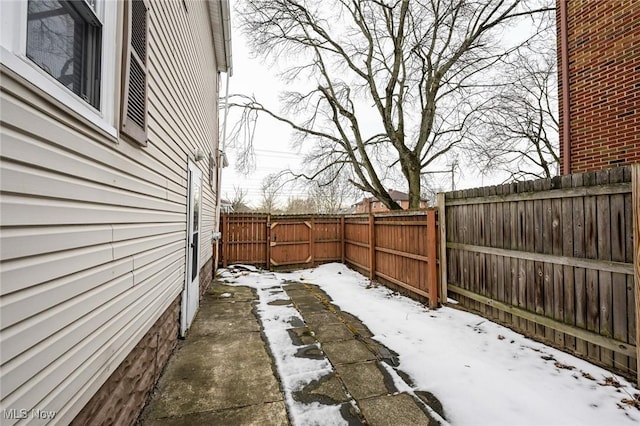 yard covered in snow with a fenced backyard