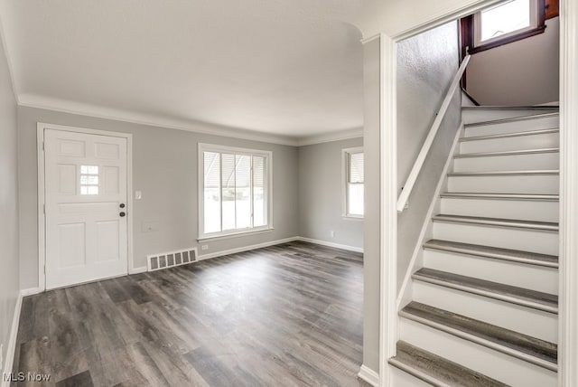 entryway featuring dark wood-style floors, stairway, visible vents, and crown molding